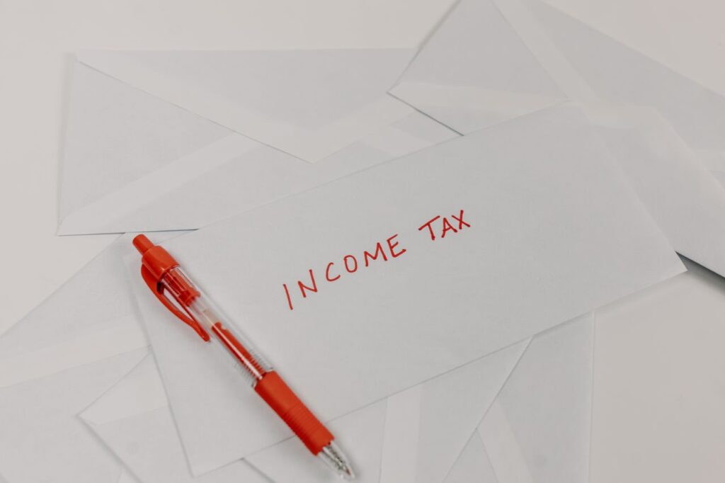 pexels photo 7111544 7111544 Studio shot of income tax envelope with red pen for accounting and tax season preparation.